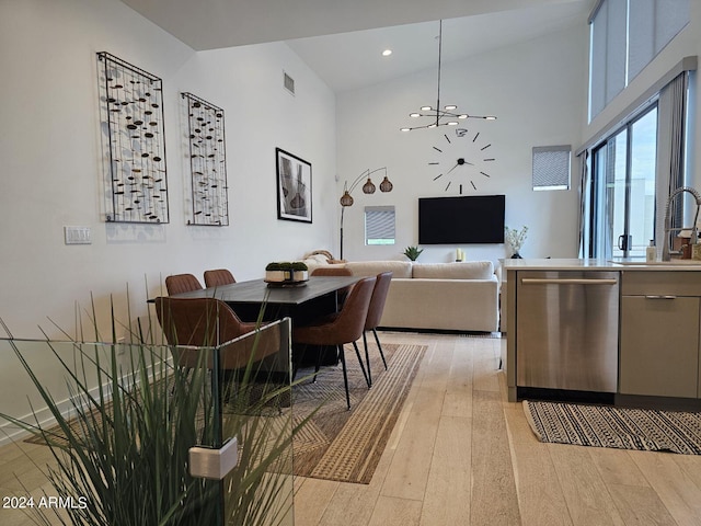 dining area with a healthy amount of sunlight, high vaulted ceiling, and light hardwood / wood-style floors