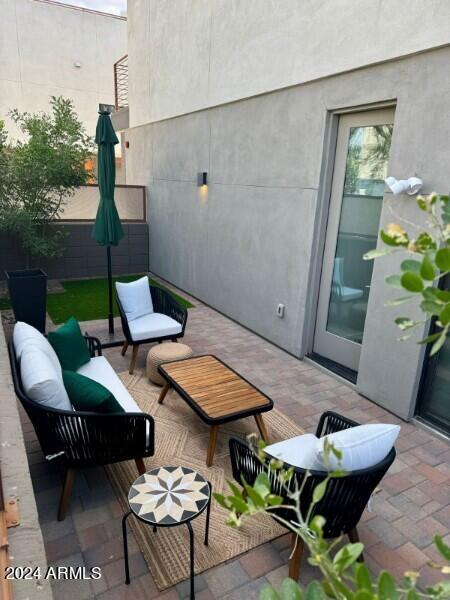 view of patio featuring outdoor lounge area and fence