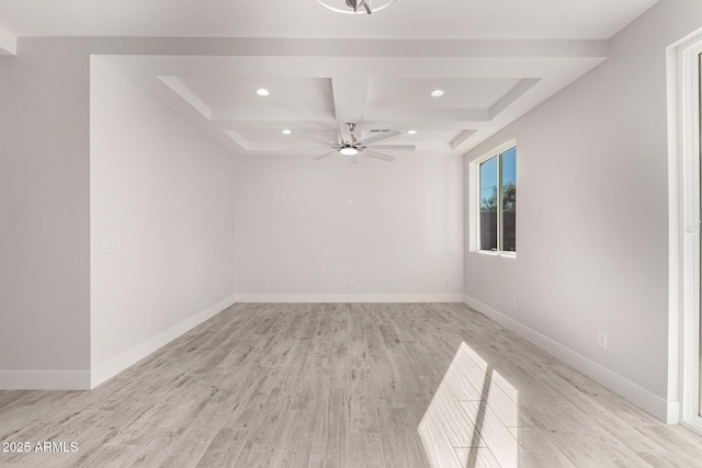 empty room with light hardwood / wood-style floors, ceiling fan, coffered ceiling, and beam ceiling