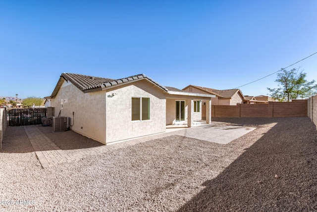 rear view of house with central AC and a patio area