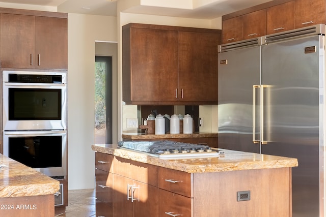 kitchen with light stone counters and appliances with stainless steel finishes