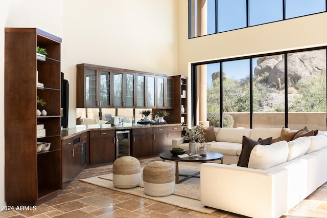 interior space featuring a high ceiling, bar area, and wine cooler