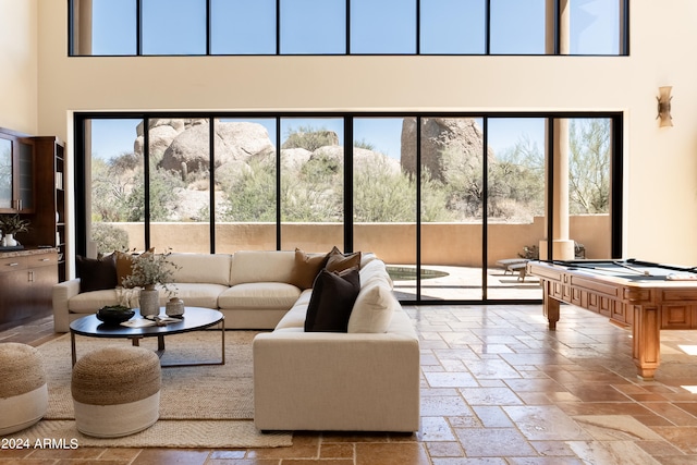 living room with a towering ceiling and pool table