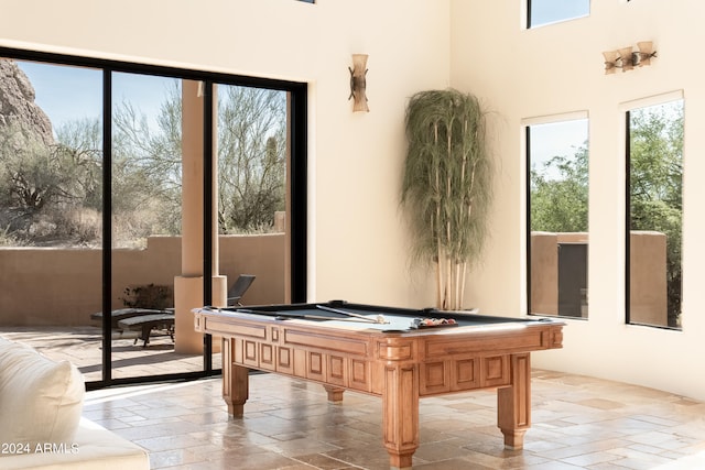 game room with a healthy amount of sunlight, a towering ceiling, and billiards