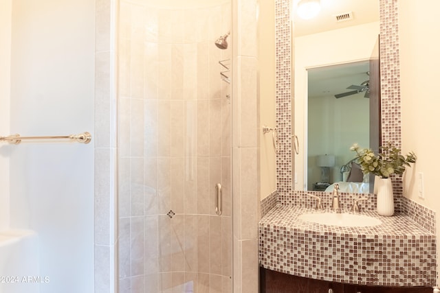 bathroom featuring ceiling fan, an enclosed shower, and vanity