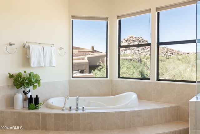 bathroom featuring tile patterned flooring and a relaxing tiled tub