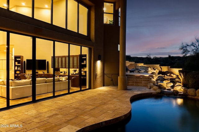 pool at dusk featuring a patio