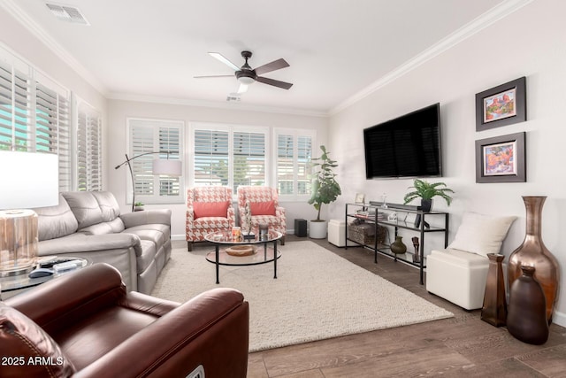 living area with visible vents, crown molding, ceiling fan, and wood finished floors