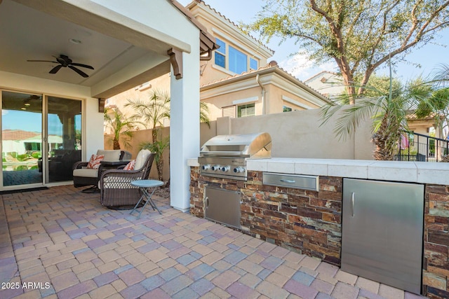 view of patio / terrace featuring an outdoor kitchen, a ceiling fan, fence, and grilling area