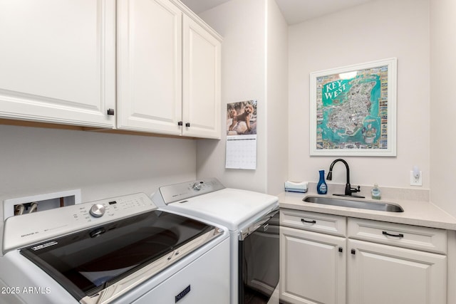 laundry area with washing machine and dryer, cabinet space, and a sink