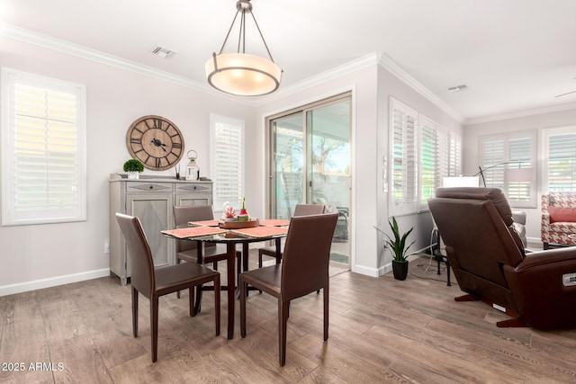 dining area featuring crown molding, baseboards, visible vents, and light wood-type flooring