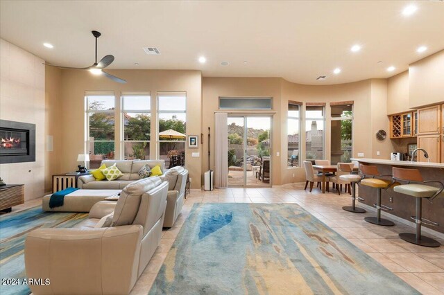 tiled living room with a healthy amount of sunlight and ceiling fan