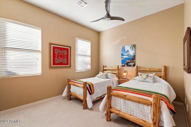 bedroom featuring ceiling fan, carpet floors, and multiple windows