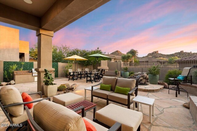 patio terrace at dusk featuring an outdoor hangout area