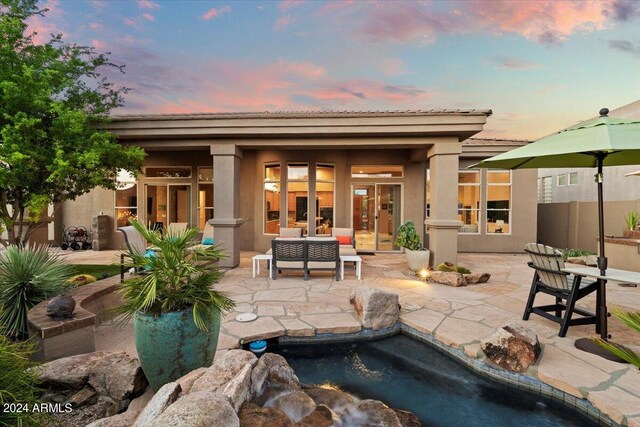 pool at dusk with a patio area