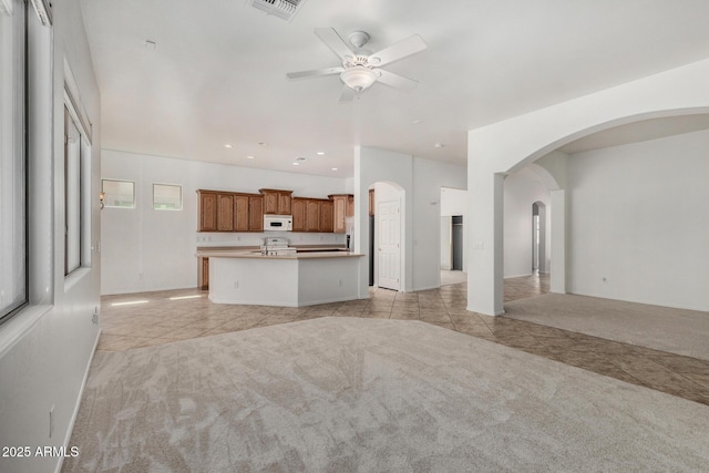 2425 W Red Range Way, Phoenix, AZ 85085 - unfurnished living room featuring light colored carpet, light tile patterned floors, a ceiling fan, arched walkways, and recessed lighting