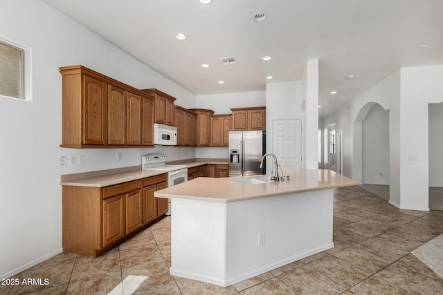 2425 W Red Range Way, Phoenix, AZ 85085 - kitchen featuring white appliances, arched walkways, recessed lighting, light countertops, and an island with sink