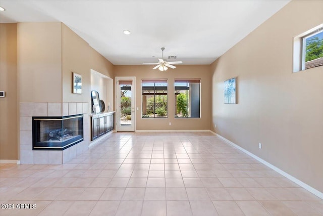 unfurnished living room with light tile patterned floors, a tile fireplace, and ceiling fan