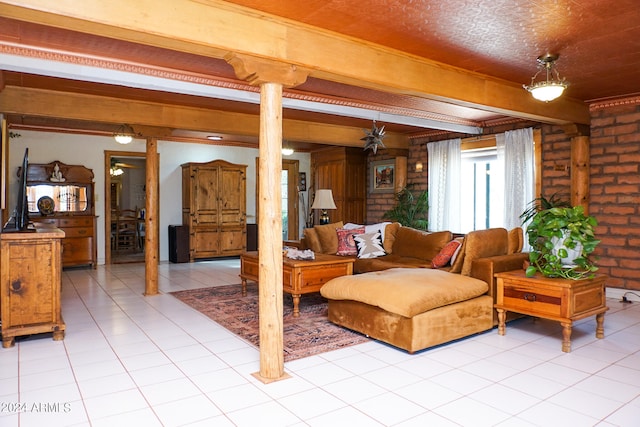 living room featuring beamed ceiling, ornate columns, brick wall, and light tile patterned floors