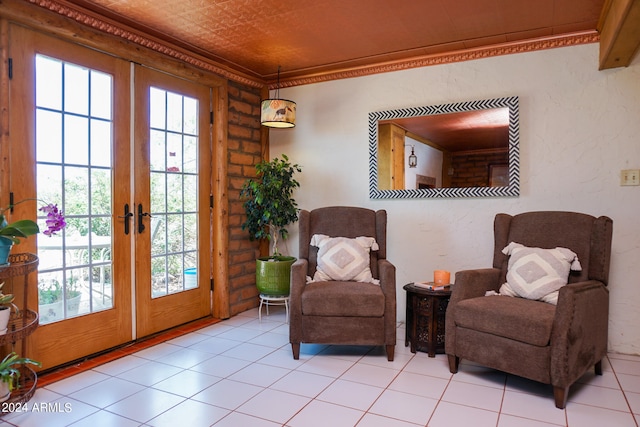 sitting room featuring light tile patterned floors, french doors, and crown molding