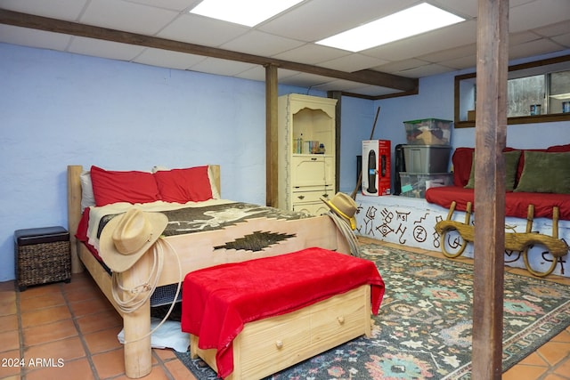 bedroom featuring tile patterned floors and a paneled ceiling