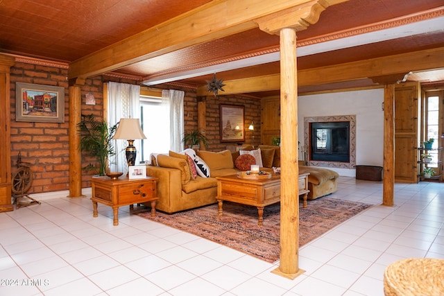 tiled living room featuring a healthy amount of sunlight, beamed ceiling, a premium fireplace, and ornate columns