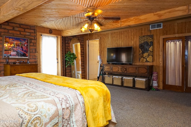 carpeted bedroom with wooden ceiling and wooden walls