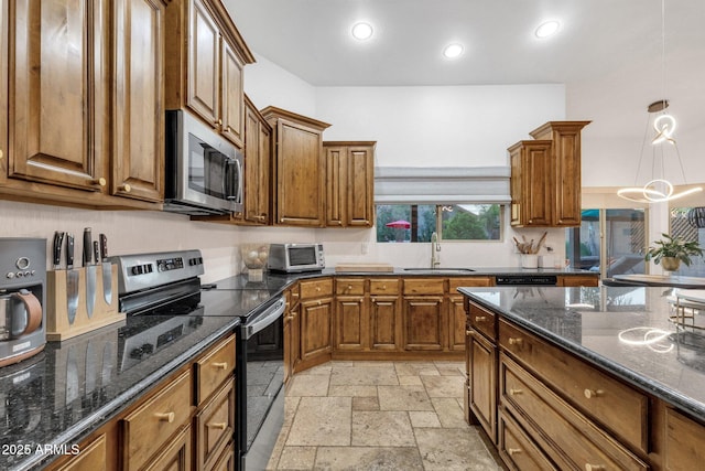 kitchen featuring stone tile floors, recessed lighting, a sink, appliances with stainless steel finishes, and brown cabinets