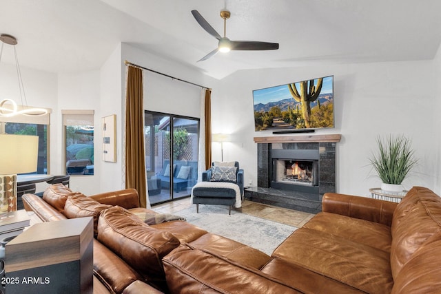 living area with a ceiling fan, lofted ceiling, and a premium fireplace