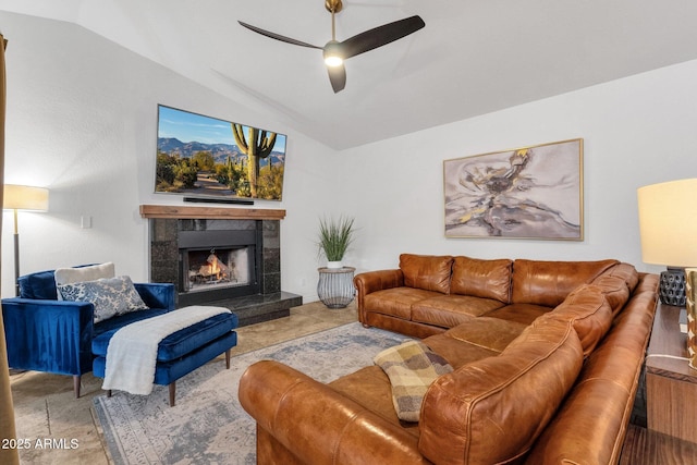 living area featuring lofted ceiling, a fireplace, and ceiling fan