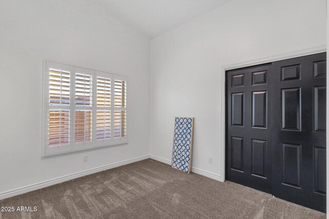 carpeted spare room featuring baseboards