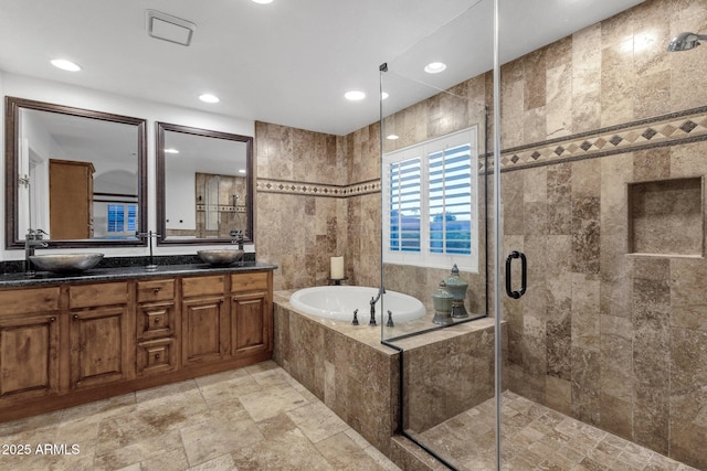 bathroom with a shower stall, double vanity, recessed lighting, a sink, and a garden tub