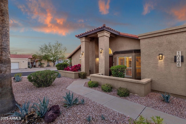 mediterranean / spanish home with a tile roof and stucco siding