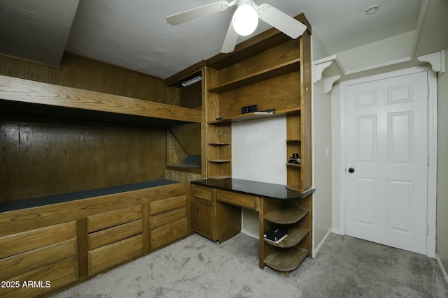 interior space with ceiling fan and built in desk