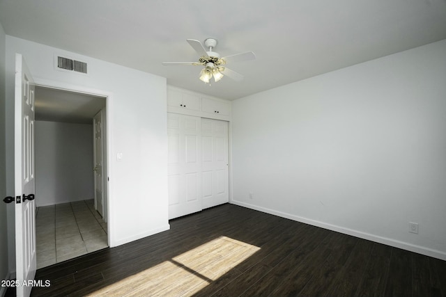 unfurnished bedroom featuring ceiling fan, a closet, and dark hardwood / wood-style floors