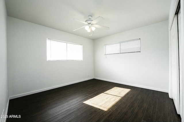 unfurnished room with a healthy amount of sunlight, ceiling fan, and dark wood-type flooring