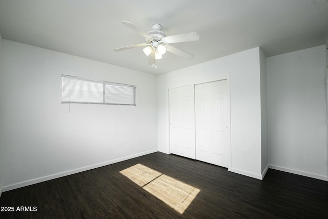 unfurnished bedroom with ceiling fan, dark hardwood / wood-style flooring, and a closet