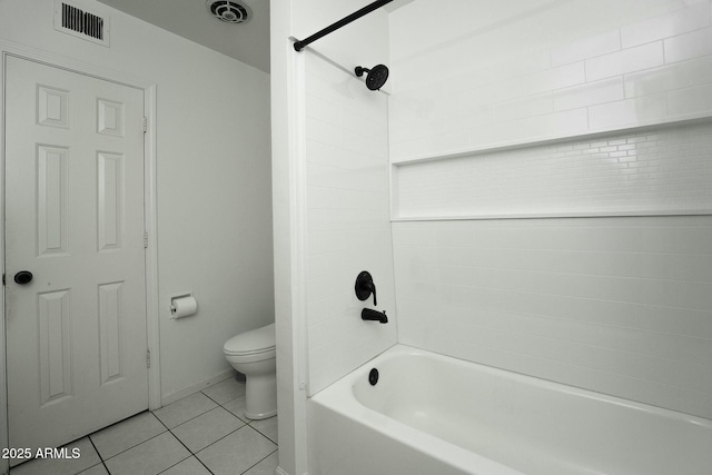 bathroom with tile patterned flooring, toilet, and tiled shower / bath