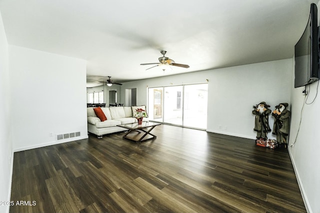 living room featuring ceiling fan and dark wood-type flooring