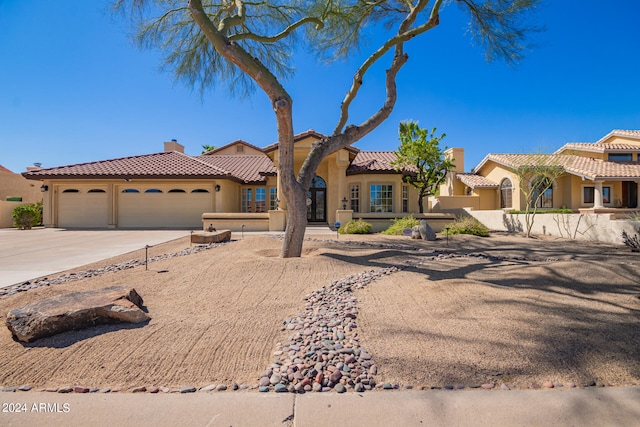 mediterranean / spanish-style house with a garage