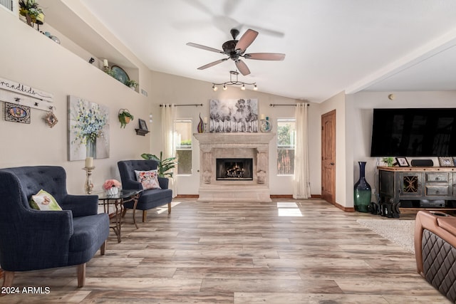 living room featuring lofted ceiling, ceiling fan, and light hardwood / wood-style floors