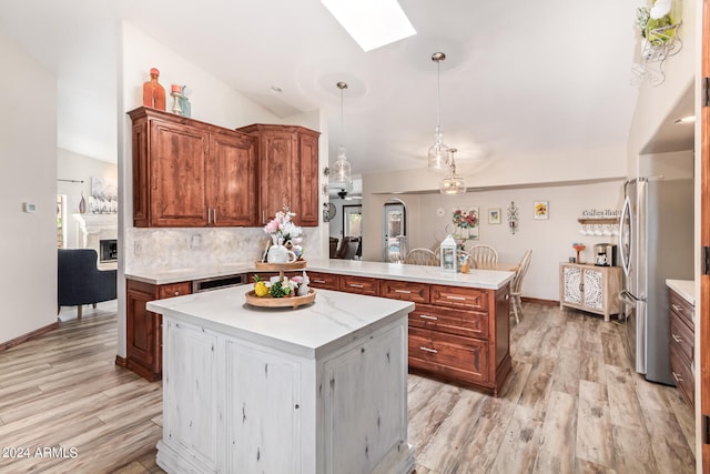 kitchen featuring light hardwood / wood-style flooring, tasteful backsplash, lofted ceiling with skylight, and a center island