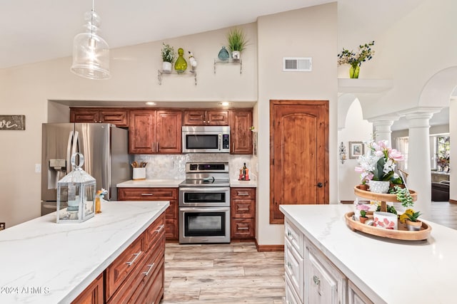 kitchen with appliances with stainless steel finishes, light hardwood / wood-style flooring, tasteful backsplash, decorative light fixtures, and white cabinetry