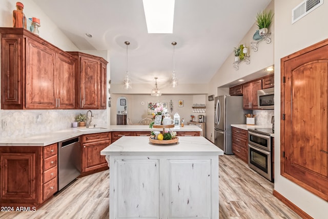 kitchen with tasteful backsplash, vaulted ceiling, appliances with stainless steel finishes, and sink