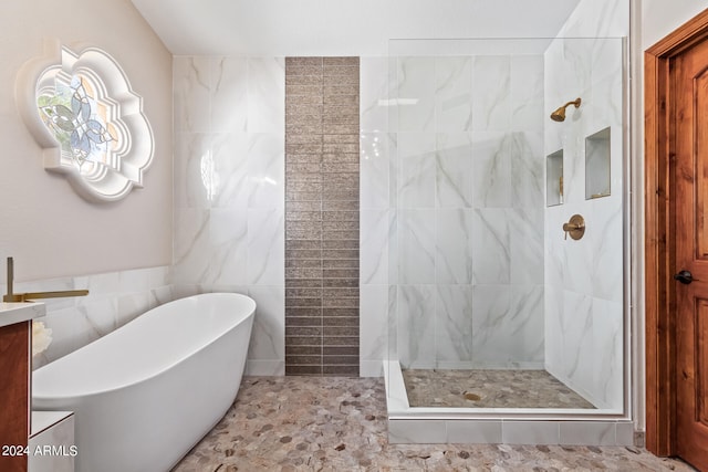 bathroom featuring vanity, tile floors, independent shower and bath, and tile walls