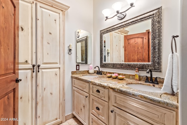 bathroom featuring double vanity and an inviting chandelier