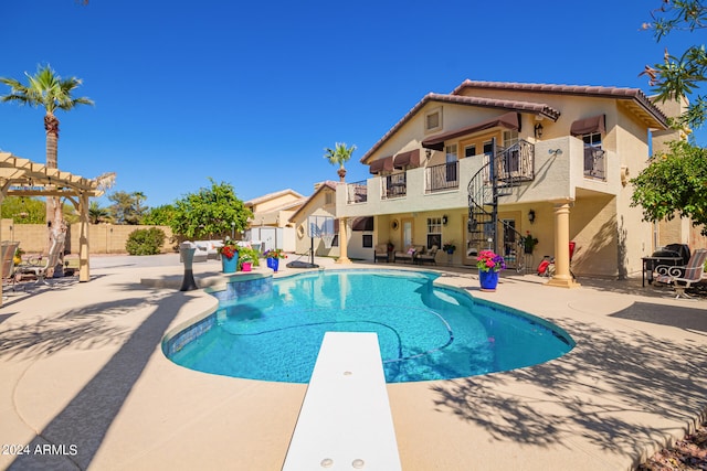 view of swimming pool with a patio, a pergola, and a diving board