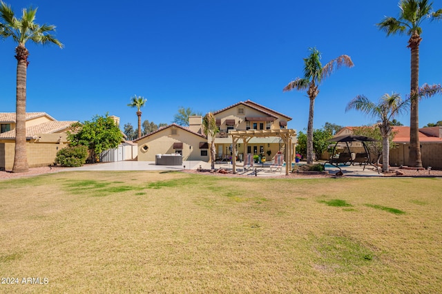 rear view of property with a pergola, a lawn, and a patio area