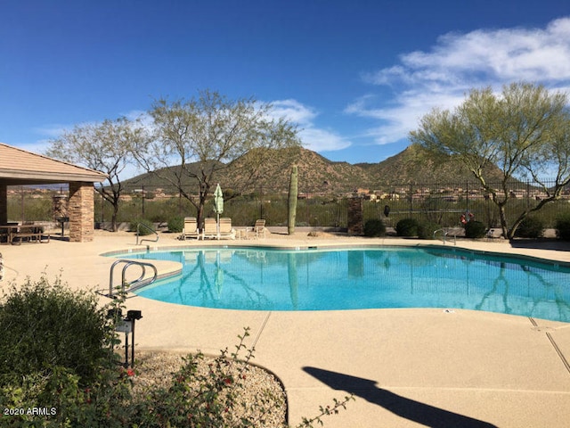 view of pool featuring a patio area and a mountain view