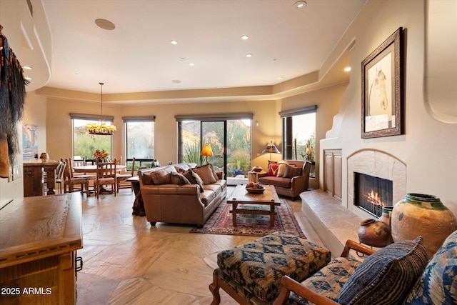 living room featuring a chandelier, recessed lighting, a healthy amount of sunlight, and a fireplace